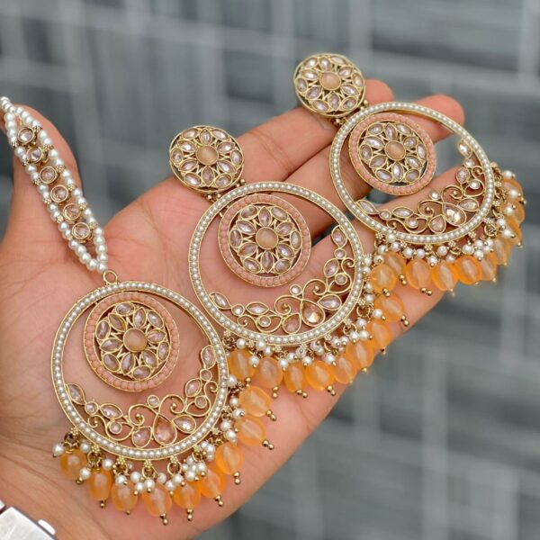 Beautiful premium quality reverse Ad melon orange coloured artificial stone, pearl earrings and tilak made of base metal alloy and gold plated and presented in hand holding